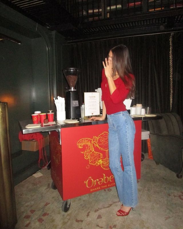 레드 톱과 데님 진의 조합으로 홀리데이 무드를 낸 벨라 하디드. 인스타그램 @bellahdid