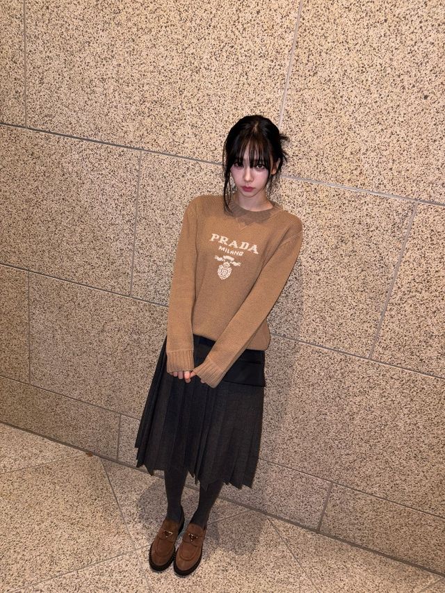 카멜 컬러 스웨터에 다크 그레이 롱 플리츠 스커트를 착용한 카리나. 인스타그램 @katarinabluu