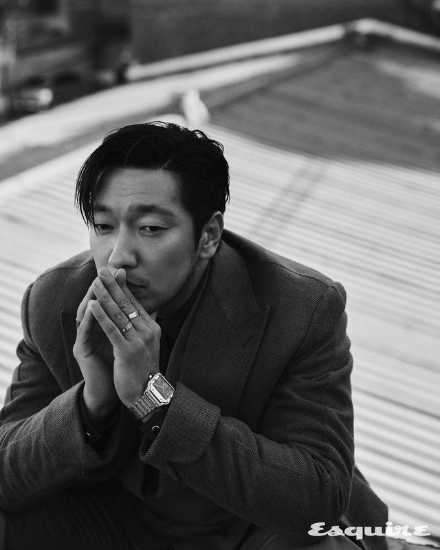 앤트러사이트 그레이 다이얼의 산토스 드 까르띠에 듀얼 타임 워치, 왼손 중지에 낀 화이트 골드 LOVE 러브 링, 왼손 약지에 낀 다이아몬드 세팅의 화이트 골드 LOVE 링, 오른손 약지에 낀 화이트 골드 LOVE 라지 링 모두 까르띠에. 코트, 재킷, 셔츠, 팬츠 모두 테일러블.