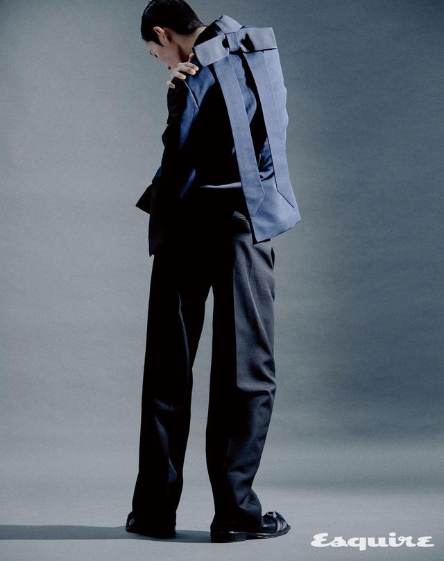 보 장식 네이비 실크 새틴 쿠튀르 재킷, 팬츠, 새틴 보 디테일 카프스킨 부츠 모두 가격 미정 디올 맨.