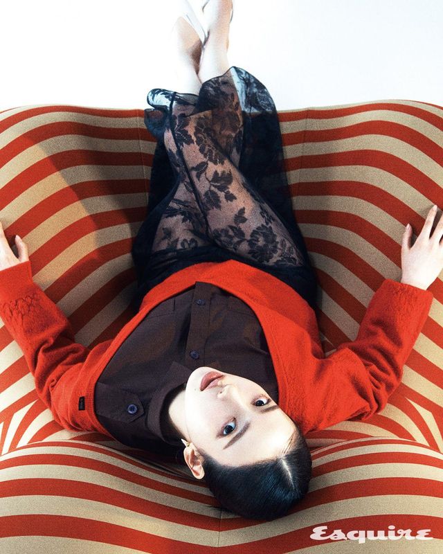 울 스웨터, 포플린 셔츠, 서스펜더 스커트, 포플린 브리프, 페이턴트 슬링백, 이터널 골드 스몰 이어링 모두 프라다.