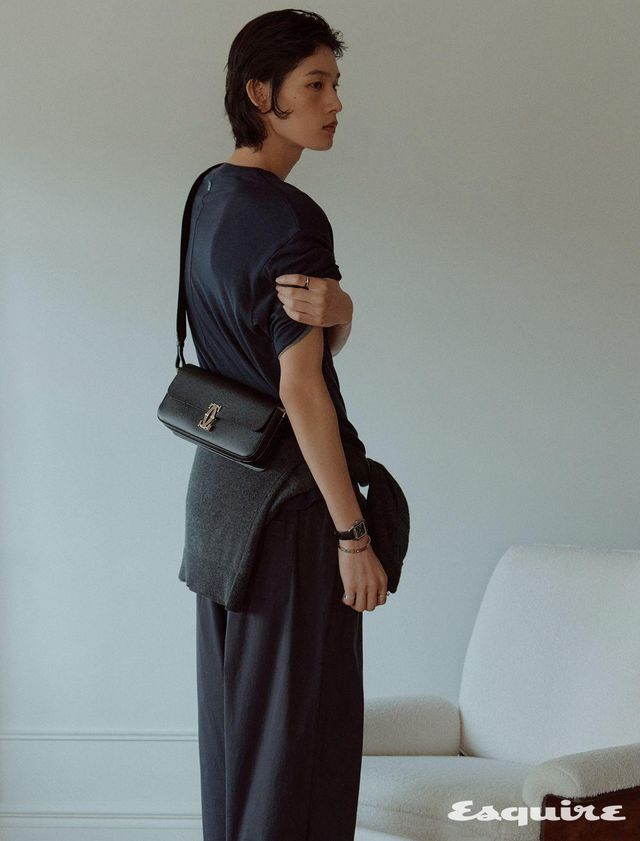 왼손 검지에 낀 화이트 골드, 세라믹 트리니티 링, 오른손에 착용한 블랙 스퀘어 다이얼 산토스 뒤몽 라지 워치, 브릴리언트 컷 다이아몬드를 장식한 화이트 골드 LOVE 미디엄 브레이슬릿, 검지에 낀 화이트 골드 저스트 앵 끌루 링, 소지에 낀 화이트 골드 LOVE 언리미티드 링, C 드 까르띠에 백. 톱, 스웨터 모두 렉토. 팬츠 테클라.