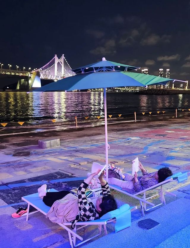 밤에는 야경이 비치는 바다를 바라보며 파라솔 아래 누워 독서할 수 있다. / 출처: 부산바다도서관 인스타그램