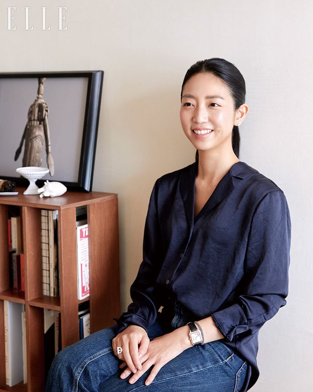 책장 옆에서 미소 짓는 추성아 큐레이터. 