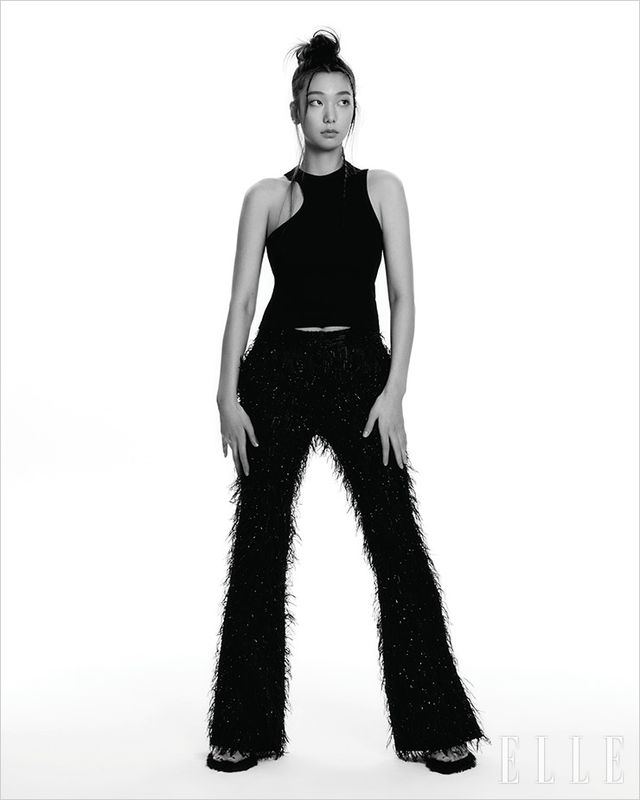 블랙 슬리브리스 톱은 Axel Arigato. 깃털 장식의 팬츠는 YCH. 페이크 퍼 뮬은 Gucci.