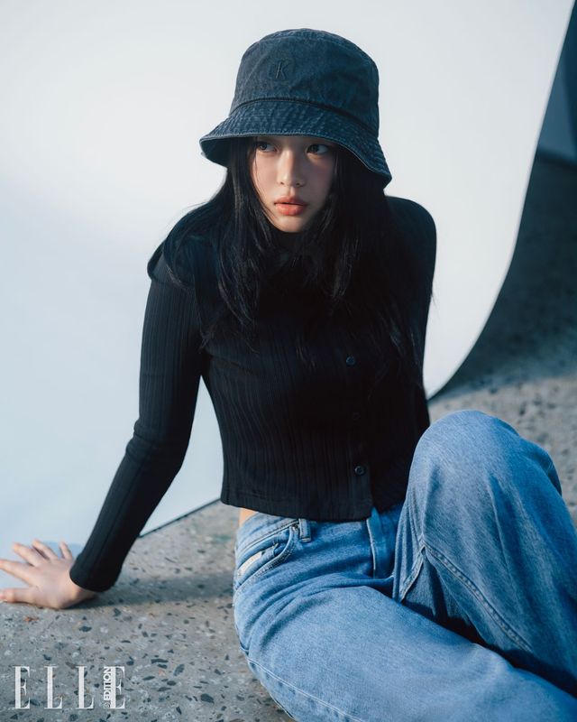 하니가 입은 크롭 베스트, 폴로 셔츠, 루즈한 핏의 데님팬츠, 데님 버킷 햇은 모두 Calvin Klein Jeans.