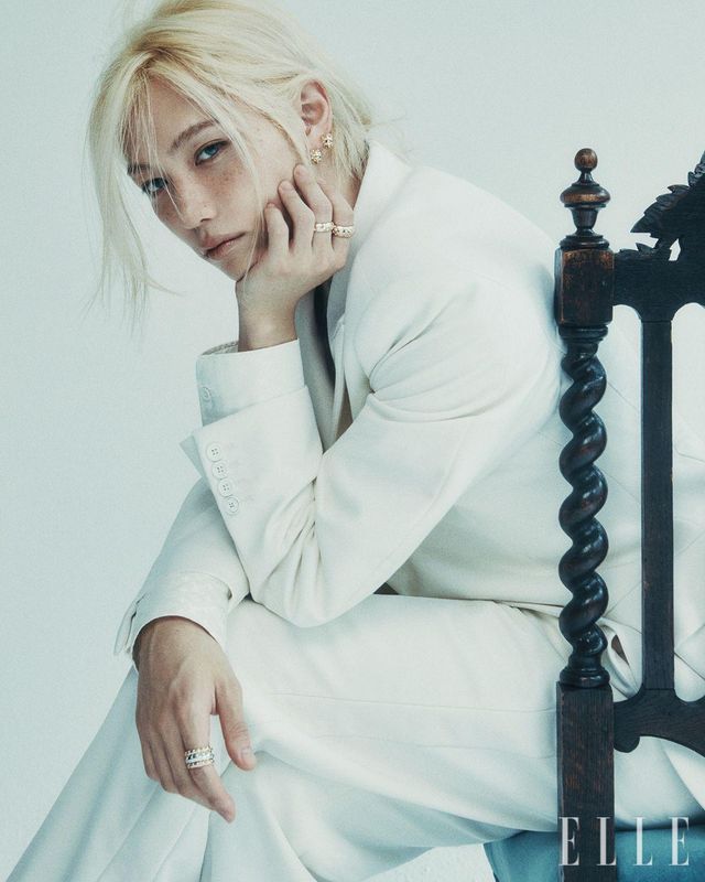 한쪽 귀에 레이어드한 르 다미에 드 루이 비통 후프 이어링과 왼손 검지에 착용한 옐로골드 르 다미에 드 루이 비통 더블 링, 중지에 착용한 르 다미에 드 루이 비통 라지 링, 오른손에 레이어드한 옐로골드 르 다미에 드 루이 비통 링, 화이트골드 르 다미에 드 루이 비통 링, 싱글 버튼 턱시도 재킷과 엠브로이더리 셔츠, 턱시도 팬츠는 모두 Louis Vuitton.