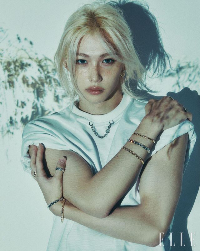 다이아몬드 세팅 르 다미에 드 루이 비통 후프 이어링과 왼손에 착용한 화이트골드 르 다미에 드 루이 비통 라지 브레이슬릿, 옐로골드 르 다미에 드 루이 비통 라지 브레이슬릿, 엄지에 착용한 화이트골드 르 다미에 드 루이 비통 링, 중지에 착용한 옐로골드 르 다미에 드 루이 비통 라지 링, 오른손에 레이어드한 옐로골드 르 다미에 드 루이 비통 브레이슬릿, 화이트골드 르 다미에 드 루이 비통 라지 브레이슬릿, 검지에 착용한 옐로골드 르 다미에 드 루이 비통 링, 약지에 레이어드한 르 다미에 드 루이 비통 링, 체인 장식의 화이트 티셔츠는 모두 Louis Vuitton.