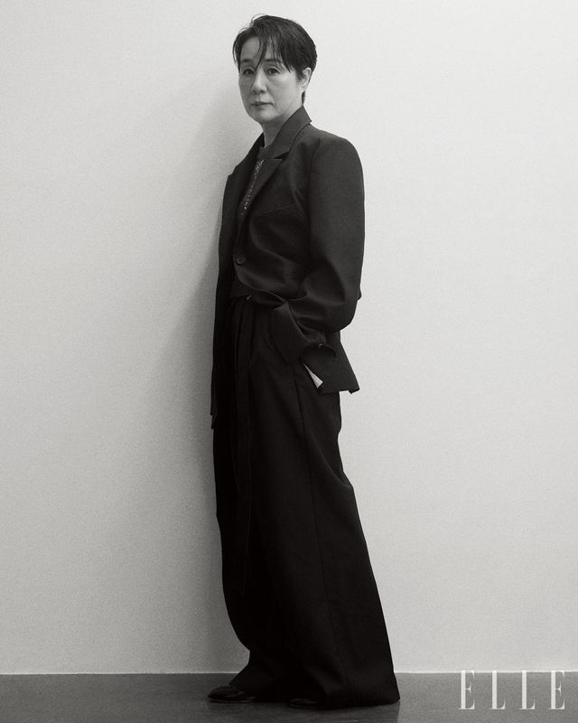 골드 세퀸 장식의 그레이 니트 톱은 Ermanno Firenze. 솔리드 블랙의 박시한 재킷은 Bourie. 벨티드 랩 트라우저는 COS. 블랙 에나멜 슈즈는 Carel Paris.