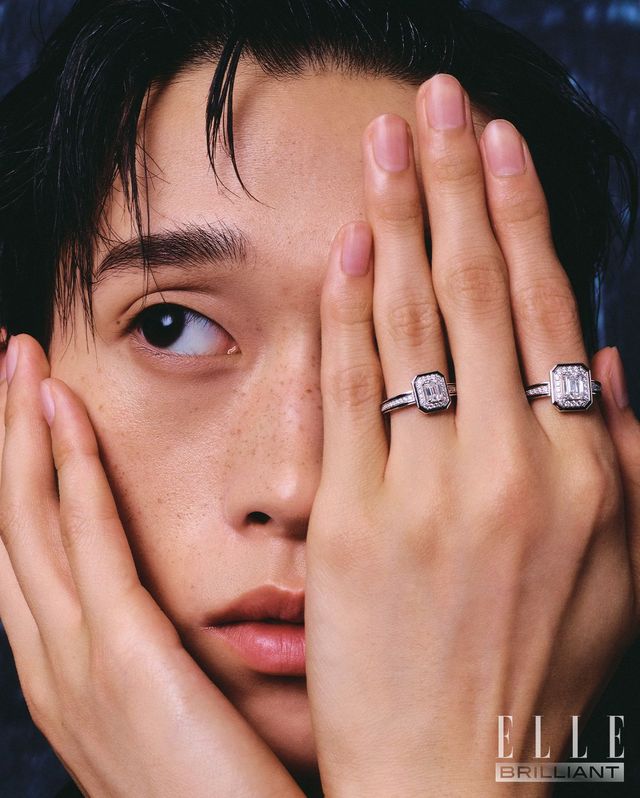 약지에 착용한 에메랄드 컷 다이아몬드를 중심으로 라운드 다이아몬드와 블랙 래커를 세팅한 ‘방돔 리즈레’ 링, 검지에 착용한 18K 화이트 골드에 블랙 래커, 1개의 에메랄드 컷 다이아몬드, 38개의 라운드 다이아몬드를 세팅한 ‘방돔 리즈레 솔리테어’ 링은 모두 BOUCHERON.