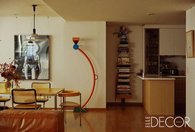 거실과 이어지는 다이닝 룸. 벽에는 모노크롬 톤의 페인팅을 전개하는 일본 작가 도무 고키타의 작품이 걸려 있다. 에토레 소트사스 디자인의 컬러플한 플로어 스탠드도 인상적이다. 
