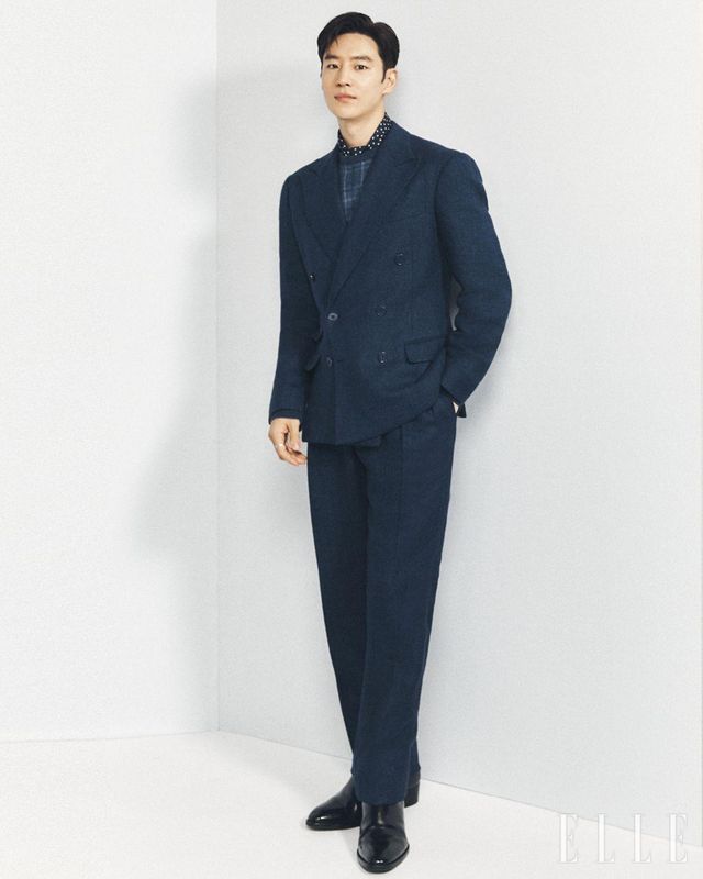 이제훈이 착용한 테일러드 헤링본 재킷과 플레드 캐시미어 크루넥 스웨터, 그레고리 핸드 테일러드 수트 트라우저는 모두 Ralph Lauren Purple Label.