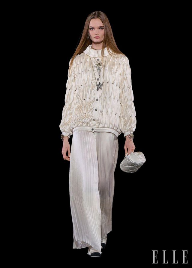 깃털과 플라워 장식을 전문으로 하는 르마리에 공방과 플리츠 장인인 로뇽 공방이 함께 제작한 블랙 드레스, 실크 새틴 재킷과 스커트. 