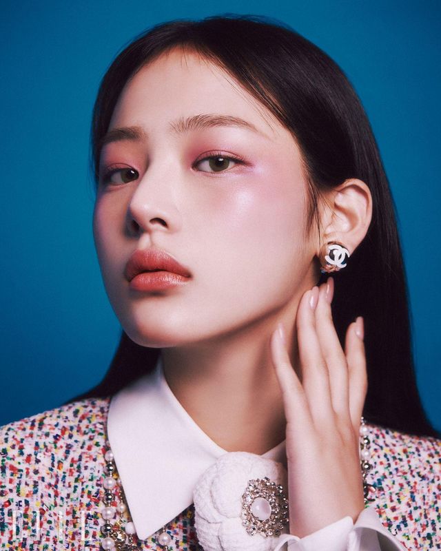 카메라를 응시하는 민지의 아우라! 레 베쥬 아이섀도우 팔레트, 쿨에 들어 있는 톤다운된 모브빛 섀도로 완성한 아이 메이크업이 아우라에 한층 더 힘을 싣는다. 눈 밑부터 광대뼈 부근을 N°1 DE CHANEL 레드 까멜리아 립 앤 치크 밤, 2 헬시 핑크로 물들여 베이스 단계에 바른 레 베쥬 쿠션의 윤기와 만나 그 생기와 광택이 극대화되도록 한다. 입술에 바른 컬러는 루쥬 코코 플래쉬, 90 쥬르. 사용 제품은 모두 Chanel. 트위드 재킷과 화이트 까멜리아 코르사주, 펄 네크리스와 이어링은 모두 Chanel.