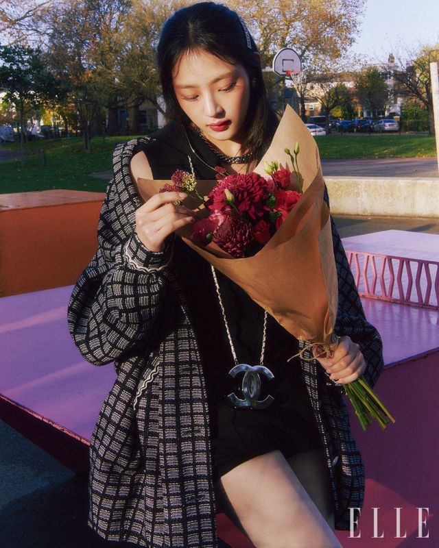 런던의 겨울 햇살에 더욱 따사롭게 빛나는 민지의 눈가는 레 베쥬 아이섀도우 팔레트, 웜으로 완성한 것. 소프트 베이지와 코럴 핑크, 피치 베이지빛 섀도를 점층적으로 발라 자연스럽고 깊은 눈매를 연출했다. 따뜻한 코럴 핑크빛의 연장선상에서 광대뼈까지 색감이 원 톤으로 내추럴하게 연결되도록 N°1 DE CHANEL 레드 까멜리아 립 앤 치크 밤, 2 헬시 핑크를 사용해 애플 존까지 넓게 혈색을 표현해 준다. 입술을 물들인 라즈베리 핑크빛 립스틱은 루쥬 코코 플래쉬, 91 보헴. 사용 제품은 모두 Chanel. 블랙 후디드 점프수트와 코트, 더블 C 로고의 체인 백과 헤어핀, 액세서리는 모두 Chanel. 체크무늬 타이츠는 스타일리스트 소장품.