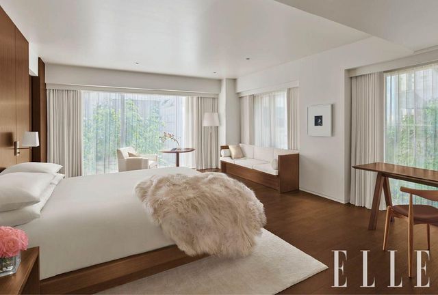 짙은 색의 호두나무와 크림색의 가구가 어우러져 전통적이면서도 미니멀한 객실 내부.