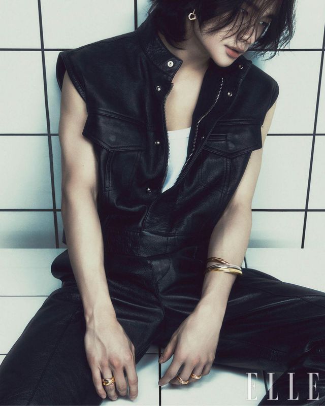 다이아몬드를 세팅한 화이트골드 · 핑크골드 · 옐로골드 소재의 ‘트리니티’ 이어링, 화이트골드 · 핑크골드 · 옐로골드 소재의 엑스트라 라지 ‘트리니티’ 브레이슬릿, 오른손에 착용한 라지 ‘트리니티’ 링, 왼손 중지와 약지에 착용한 ‘트리니티’ 링은 모두 Cartier. 블랙 레더 베스트와 팬츠는 모두 Versace. 