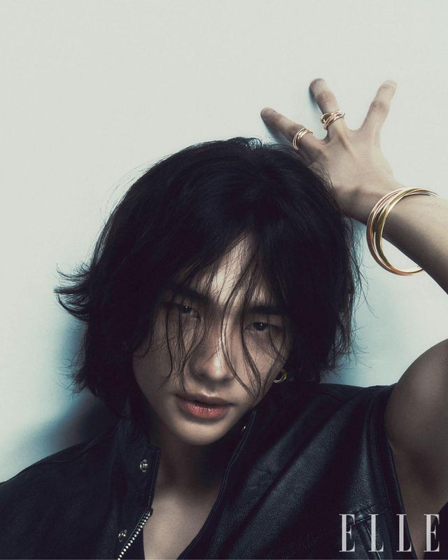 중지에 착용한 화이트골드 · 핑크골드 · 옐로골드 소재의 ‘트리니티’ 링과 약지에 착용한 ‘트리니티’ 링, 화이트골드 · 핑크골드 · 옐로골드 소재의 엑스트라 라지 ‘트리니티’ 브레이슬릿과 다이아몬드를 세팅한 '트리니티' 이어링은 모두 Cartier. 블랙 가죽 베스트는 Versace.