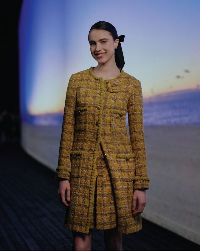 옐로 트위드 수트에 보 핀으로 포인트를 준 마거릿 퀄리. 