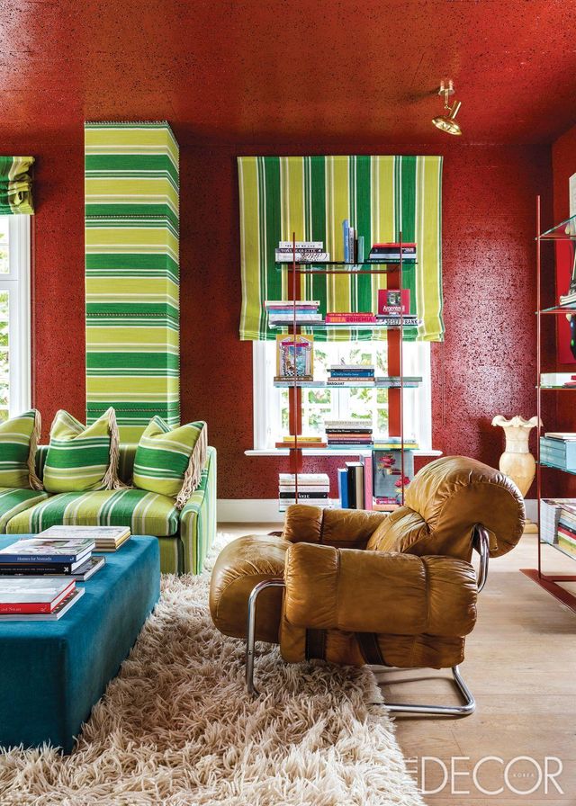서재는 코르크 단열 보드 위에 빨간색으로 페인트칠한 벽과 가구 제작소 콜레트 & 빅터(Collett & Victor)와 협업해 만든 녹색 스트라이프 패브릭 소파와 커튼, 기둥이 대조를 이룬다. 귀도 팔레스키니(Guido Faleschini)가 만든 가죽과 메탈 소재의 ‘투크로마(Tucroma)’ 1인용 소파는 마리아니(Mariani). 소파 아래는 70년대의 모로코 카펫. 래커드 메탈 책 선반은 개인 수집품이다.