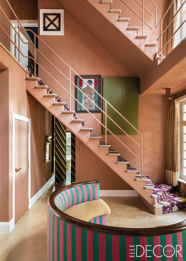 집의 출입구를 생활공간처럼 연출했다. 제이피 드메이어 & 코의 부클레 패브릭과 스트라이프 패브릭을 씌운 40년대 반원 소파는 생투앙 벼룩시장에서 구입했다. 계단 벽면에 걸린 녹색의 단색 페인팅은 성 세바스티안을 그린 1962년 작품과 조화를 이룬다. 