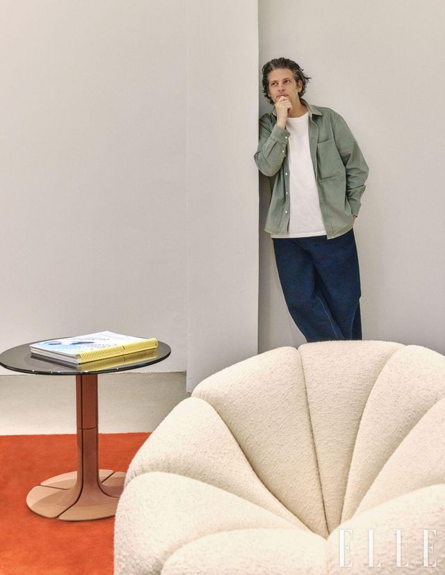 'Alpha Club' 의자 뒤에 서서 생각하는 듯한 포즈를 잡은 유쾌한 벤자민 폴랑. 