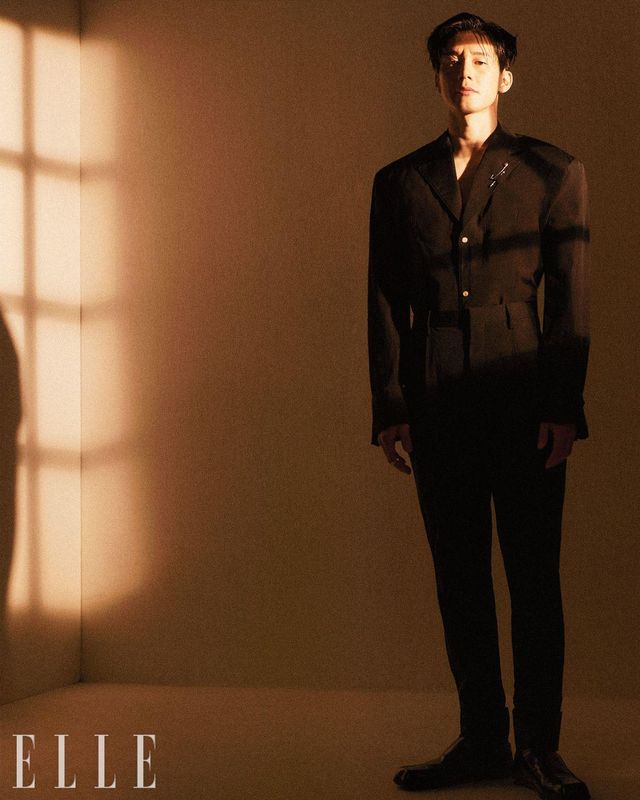 블랙 재킷과 팬츠, 로퍼는 모두 Prada. 옷핀 모양의 브로치와 일자 브로치, 검지와 새끼손가락에 낀 링은 모두 Chrome Hearts.