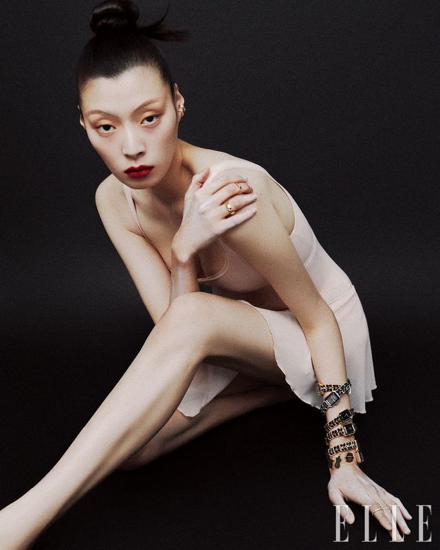 오른손 중지에 낀 ‘코코 크러쉬’ 미니 링과 약지에 낀 ‘코코 크러쉬’ 스몰 링, 왼 손목에 레이어드한 18K 옐로골드 코팅 ‘프리미에르 오리지널 에디션’ 워치, 스틸 케이스의 ‘프리미에르 아이코닉 체인’ 워치, 참 장식이 특징인 ‘프리미에르 참 꾸뛰르’ 워치, 18K 옐로골드 ‘코코 크러쉬’ 다이아몬드 미니 링, 화이트골드 ‘코코 크러쉬’ 싱글 이어링. 18K 옐로골드 ‘코코 크러쉬 다이아몬드’ 싱글 이어링은 모두 Chanel Watches & Fine Jewelry.