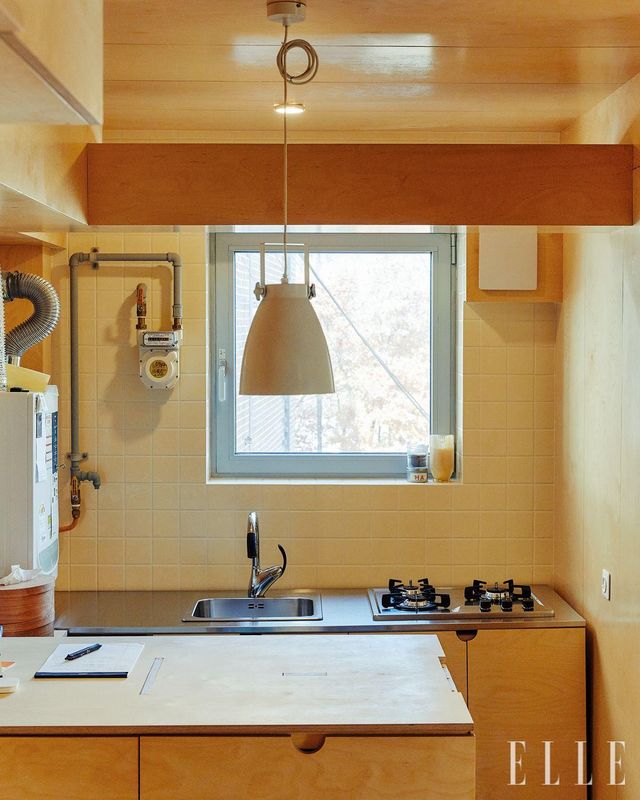 맞춤 제작한 수납장과 싱크대, 목재와 유사한 색감의 풀 보디 타일로 마감한 주방. 