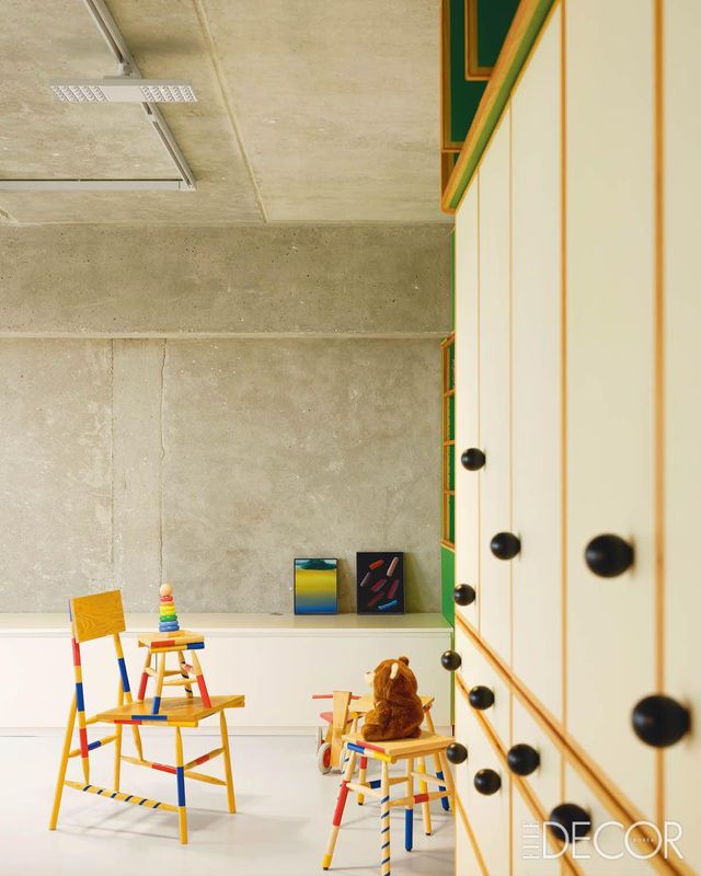 거친 질감의 콘크리트 벽을 배경으로 색색의 미카도산 체어와 그림, 초록색 캐비닛이 어우러져 만들어내는 대비가 흥미롭다.