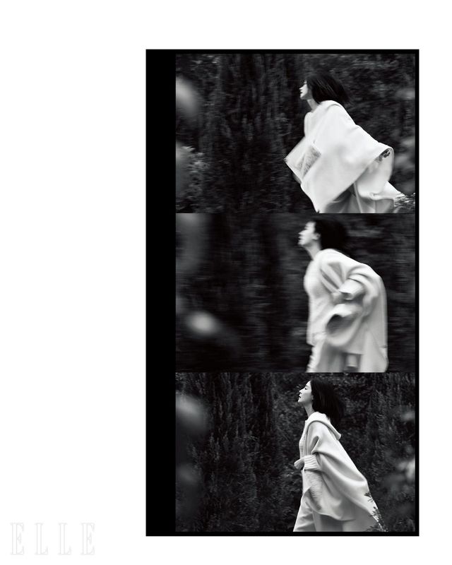 시어링 포켓 디테일의 화이트 케이프와 스퀘어 스티치 디테일의 스웨터, 와이드 팬츠는 모두 Fabiana Filippi.