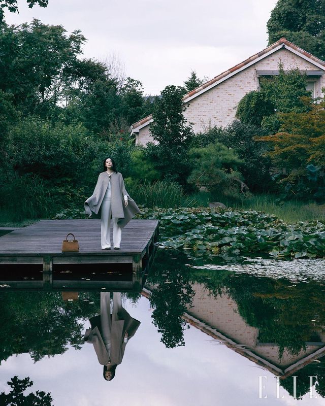 베이지 캐시미어 케이프와 스웨터, 와이드 팬츠, 스웨이드 토트백, 플랫 슈즈는 모두 Fabiana Filippi.