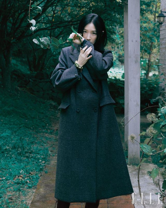 체크 패턴 더블 브레스티드 코트와 캐시미어 스웨터, 나파 레더 하이힐 부츠, 너깃 장식 브레이슬릿은 모두 Fabiana Filippi.