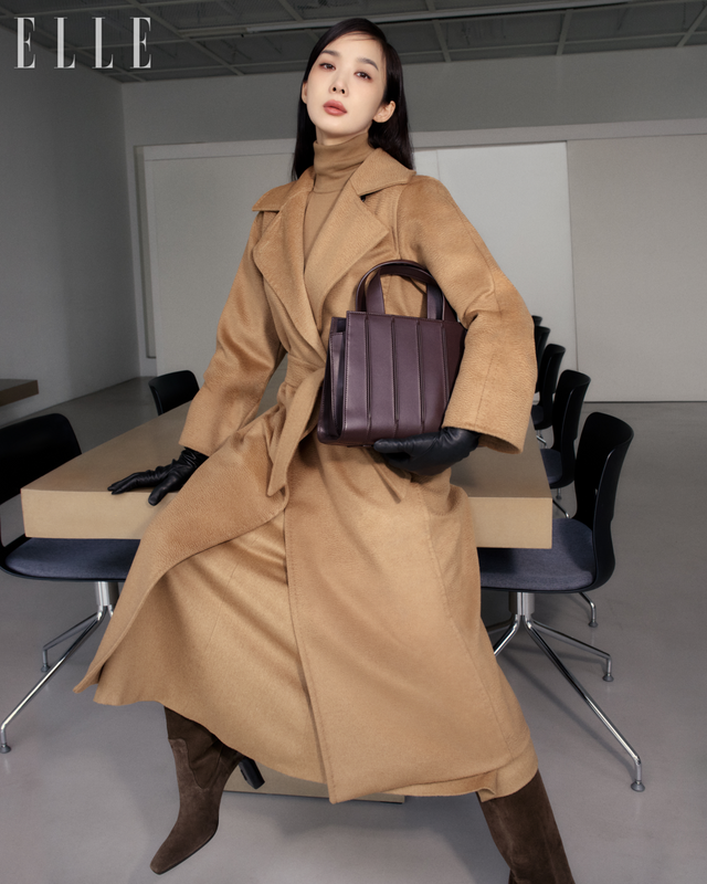 마누엘라 아이콘 코트, 스웨터, A라인 실루엣의 스커트, 글러브, 휘트니 백, 슬라우치 레더 부츠는 Max Mara. 