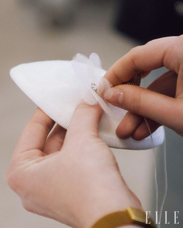 모자의 형태 위에 르 마리에의 꽃 장식을 다는 과정. 