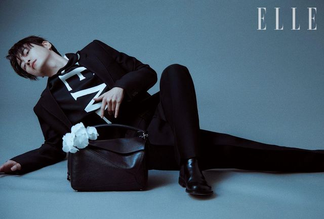 수트 재킷과 로고 드레이핑 셔츠, 수트 팬츠, 첼시 부츠, 뉴 라지 퍼즐 백은 모두 Loewe.