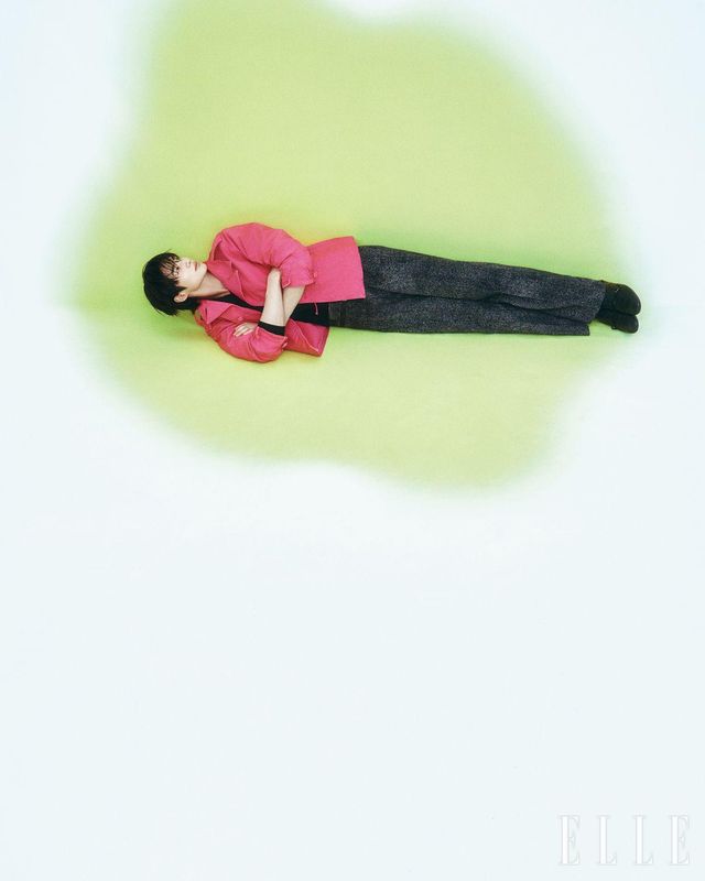 핑크 코튼 블루종 재킷과 브이넥 울 스웨터, 벨트와 트위드 패턴을 프린트한 팬츠, 더블 몽크 스트랩 슈즈는 모두 Prada.