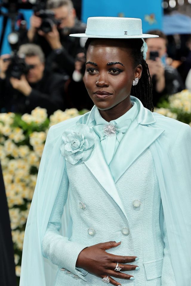 샤넬의 민트색 슈트와 케이프, 진주 장식의 보터 햇을 완벽하게 소화하며 동화처럼 우아한 순간을 맞이한 루피타 뇽오.