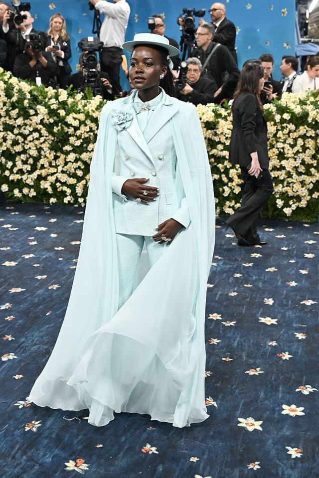 샤넬의 민트색 슈트와 케이프, 진주 장식의 보터 햇을 완벽하게 소화하며 동화처럼 우아한 순간을 맞이한 루피타 뇽오.