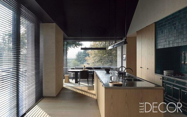 삼나무로 만든 일본식 트레이와 펠리시아 페로네(Felicia Ferrone)가 디자인한 주전자와 유리잔이 오크 테이블 위에 놓여 있다. 천장에 매달린 조명은 플로스의 인프라-스트럭처(Infra-Structure). 용암석으로 마감된 조리대는 라꼬르뉴(La Cornue).