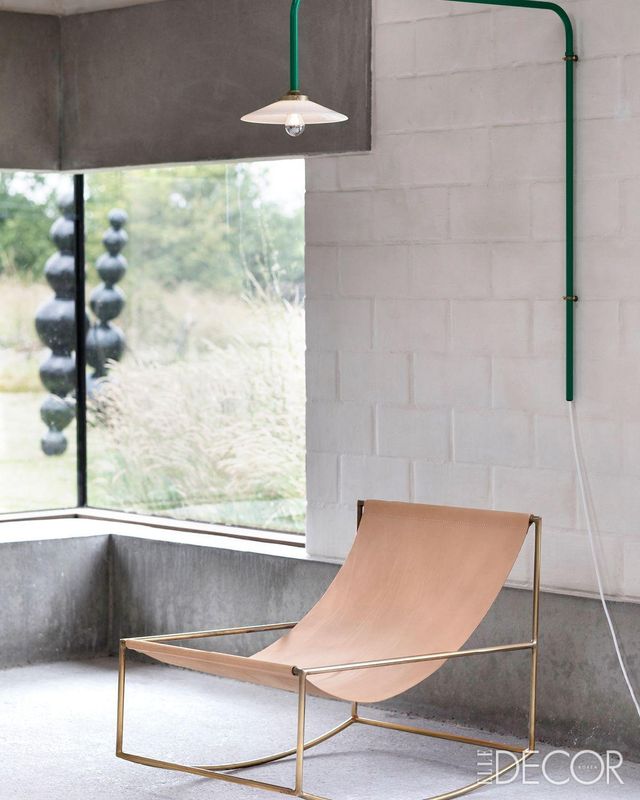 컬러 라인이 경쾌함을 주는 ‘행잉 램프(Hanging Lamp) N°5’와 그 아래에는 황동 프레임으로 제작된 ‘로킹 체어’가 놓여 있다.