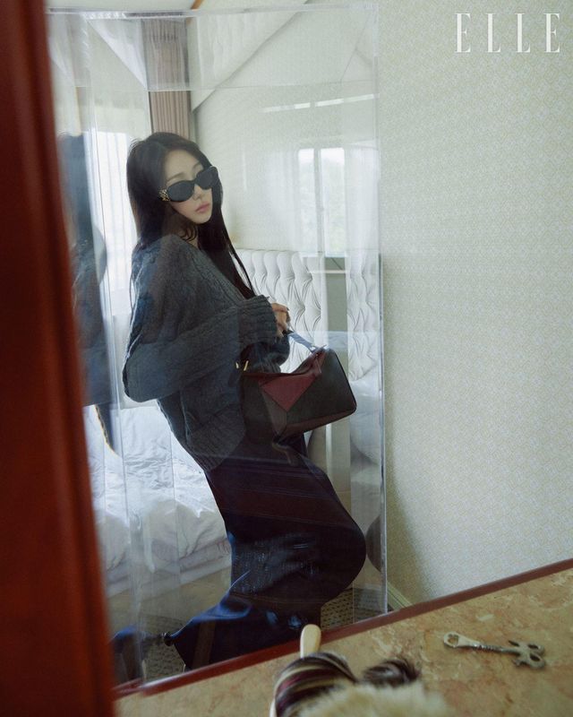 지젤이 입은 울 스웨터와 실크 트라우저, 토이 90 펌프스, 다크 그린 오벌 맥시 선글라스와 멀티컬러 나파 레더 퍼즐 스몰 백은 모두 Loewe.