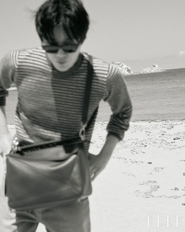 스트라이프 스웨터와 데님 팬츠, 선글라스, 나파 램스킨 라지 퍼즐 백, 스니커즈는 모두 Loewe.