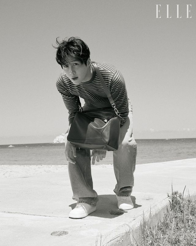 스트라이프 스웨터와 데님 팬츠, 선글라스, 나파 램스킨 라지 퍼즐 백, 스니커즈는 모두 Loewe.