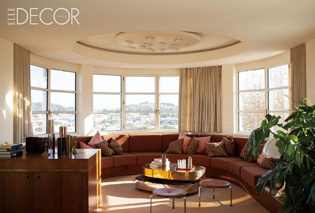 생트로페 언덕을 바라보는 거실은 배의 둥근 선체를 연상시킨다. 가에 아울렌티(Gae Aulenti)가 디자인한 아르테미데의 ‘알치노(Alcinoo)’ 테이블 램프, 가브리엘라 크레스피(Gabriella Crespi)의 ‘스쿨투라(Scultura)’ 로 테이블, 프리츠한센(Fritz Hansen)의 ‘PK33’ 스툴 등 아이코닉한 디자인의 가구들이 거실 풍경을 완성한다. 