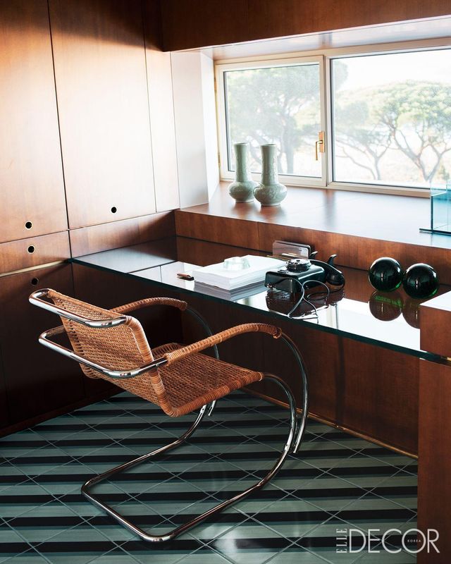 맞춤 제작한 수납장과 책상, 라탄 소재의 ‘MR20’ 암체어가 있는 서재. 