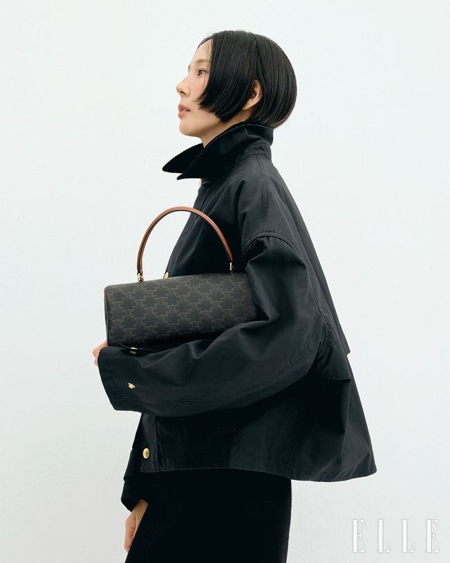 탠 트리옹프 캔버스 & 카프스킨 실리더 백, 블랙 컬러 왁스드 코튼 재킷, 울 저지 터틀넥 톱, 캐시미어 모헤어 나트 펜슬 스커트는 모두 Celine.