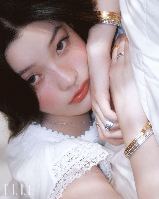 왼팔에 착용한 핑크골드, 옐로골드, 다이아몬드 세팅 화이트골드의 벨 에포크 릴 브레이슬릿, 검지에 낀 다이아몬드 세팅 핑크골드 5.7mm 벨 에포크 릴 링, 약지에 낀 화이트골드 8.3mm 벨 에포크 릴 링, 벨 에포크 릴 네크리스, 오른손 중지에 낀 핑크골드 5.7mm 벨 에포크 릴 링, 약지에 낀 화이트골드 5.7mm 벨 에포크 릴 링 오른팔에 착용한 핑크 골드, 다이아몬드 세팅의 화이트골드 벨 에포크 릴 브레이슬릿은 모두 Damiani. 드레스는 Viaplain.