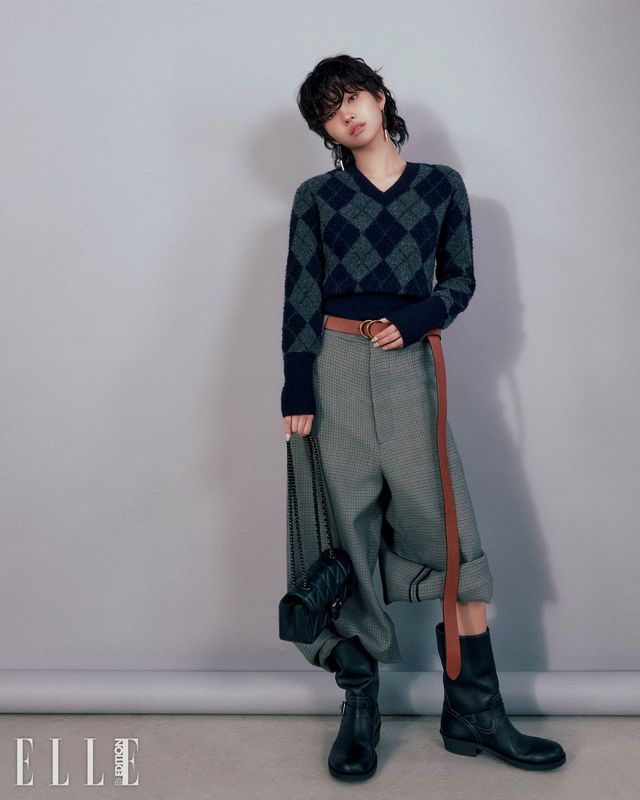 쁘띠 사이즈의 퀼팅 태비 숄더 백, 아가일 니트 가디건, 와이드 핏으로 연출한 테일러드 맨즈 런웨이 팬츠와 벨트, 바이커 부츠, 두 개의 스크류 드라이버 싱글 이어링은 모두 Coach.