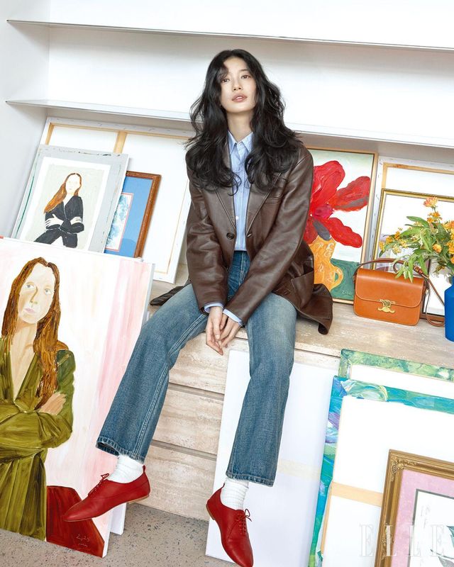 램스킨 테일러드 재킷과 스트라이프 코튼 셔츠, 부츠 컷 데님 팬츠, 양말, 트리옹프 레드 램스킨 슈즈, 트리옹프 클래식 백은 모두 Celine. 여인의 초상화와 꽃 그림은 손정민 작가의 작품. 